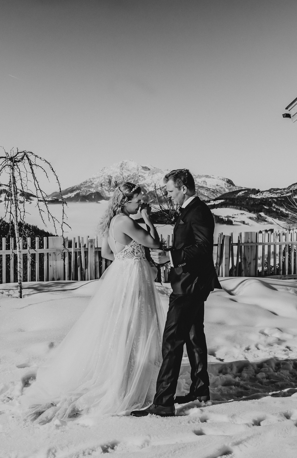 Ronja Baumbach Hochzeiten First Look Bride and groom vor einer atemberaubenden Bergkulisse in Österreich im Schnee