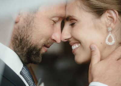 Glückliches Brautpaar am Hochzeitstag in einem intimen Moment, in dem sie die Zweisamkeit genießen.