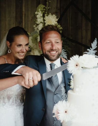 Cake cutting by the bride and groom at their mountain wedding in the Austrian Alps, wedding planner Ronja Baumbach