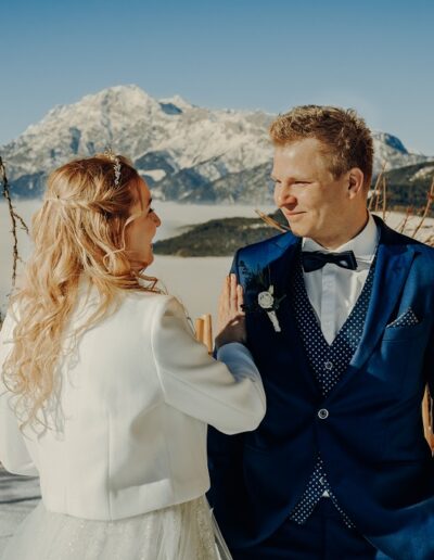 First look of the bride and groom in the sunshine at their winter wedding in the mountains