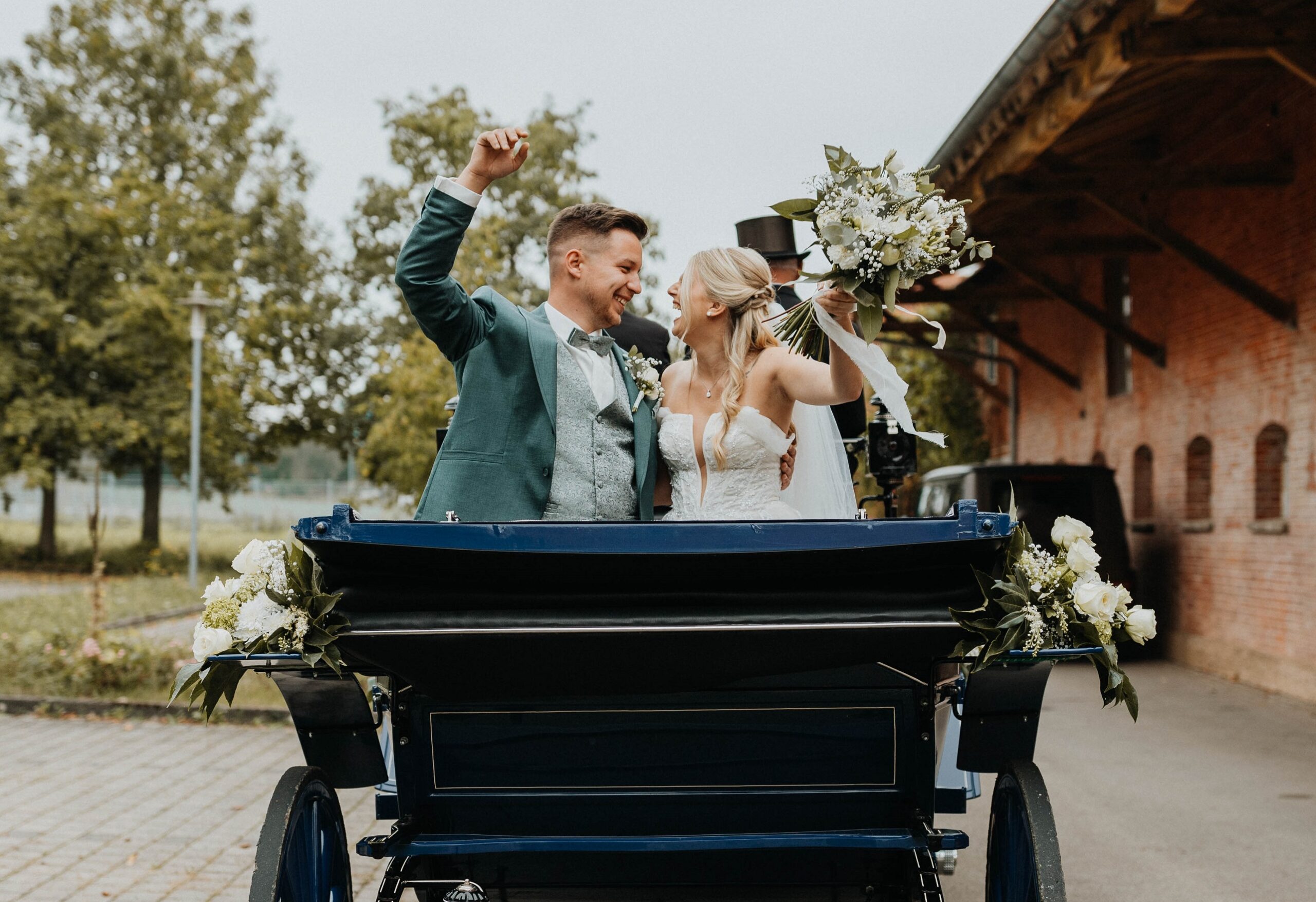 Brautpaar an ihrem Hochzeitstag in einer Kutsche