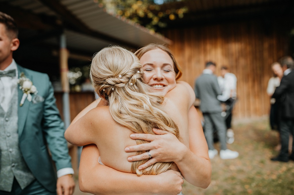Hug between wedding planner and bride at their mountain wedding