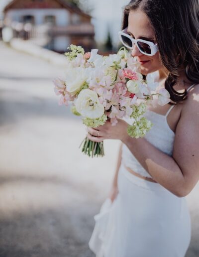 Braut mit Sonnenbrille und Brautstrauß kurz vor ihrer freien Trauung