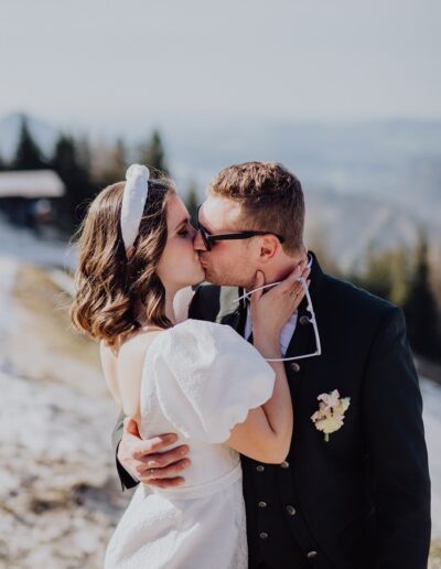 Küssendes Brautpaar auf dem Zwölferhorn bei ihrer Berghochzeit
