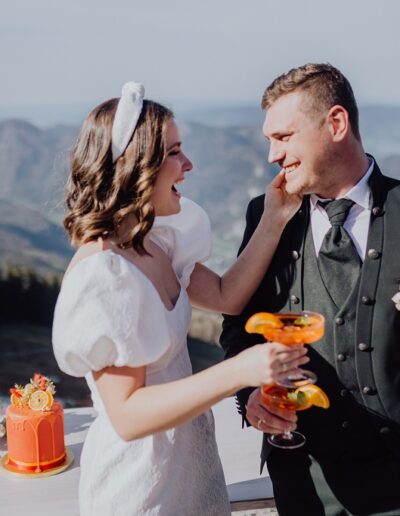 Brautpaar beim Aperol trinken auf dem Empfang ihrer Berghochzeit in Österreich