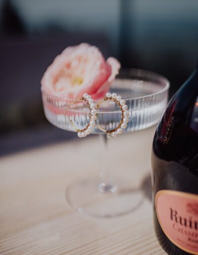 Ohrringe und Champagnerschale im Detail auf einer Berghochzeit in den Alpen