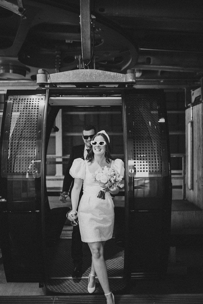 Bridal couple getting off the cable car at the mountain station in Austria