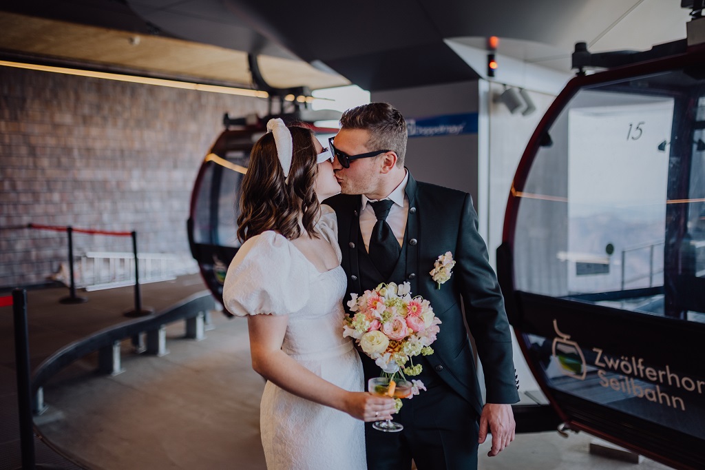 Ronja Weddings wedding planning wedding in the mountains master of ceremonies alpine wedding Oberstdorf Ötztal Kaprun Kissing bride and groom shortly before their arrival at their mountain wedding at the gondola station