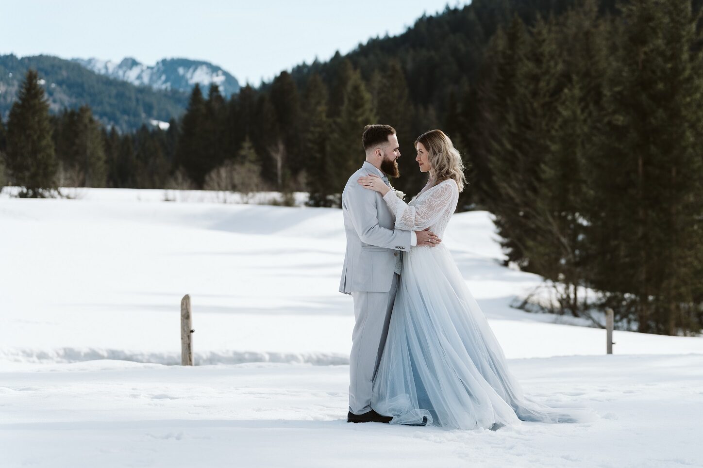 Brautpaar im Schnee bei ihrer standesamtlichen Winterhochzeit in den Bergen