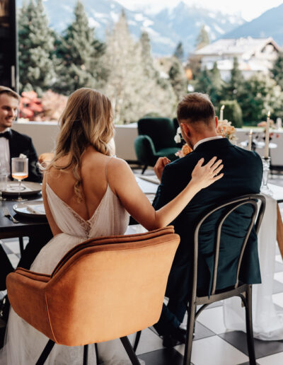 Brautpaar mit ihren Trauzeugen am Tisch bei ihrer Hochzeit in den Bergen