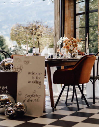 Tablesetting mit Discokugeln und Welcomeschild auf einer Berghochzeit