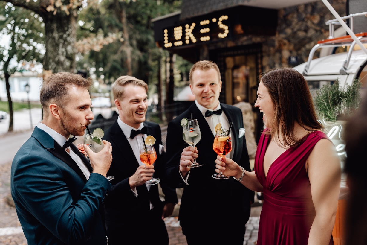 Entspannte Gäste und Bräutigam auf einer Hochzeit am Berg beim Sektempfang