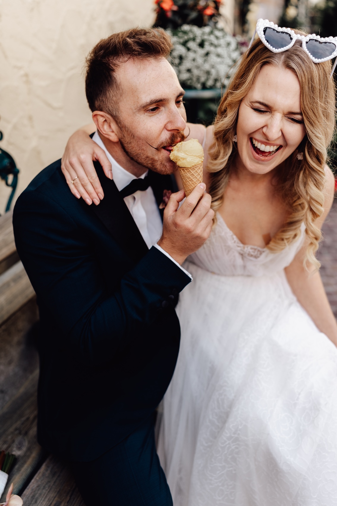 Style shoot Bride and groom in love eating ice cream at their wedding on the mountain in Austria