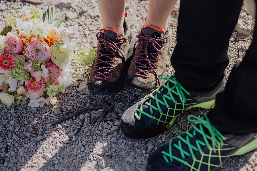 Marriage proposal in the Alps with hiking boots on the summit