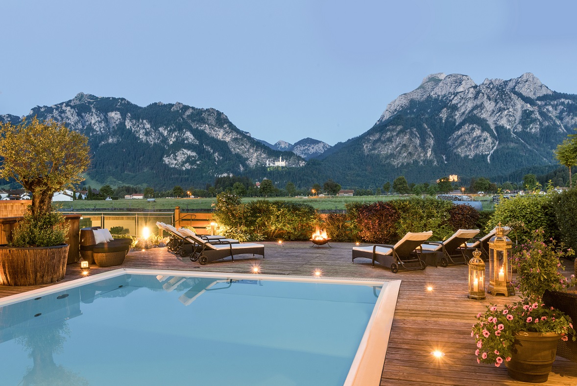 Romantischer Poolbereich im Wellnesshotel Das Rübezahl mit Blick auf die Alpen und Schloss Neuschwanstein – perfekt für Flitterwochen in Bayern