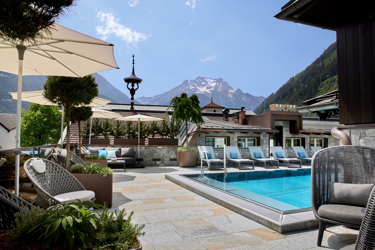 Beheizter Outdoor-Pool mit Blick auf die Alpen im Wellnesshotel in Tirol – unvergessliche Flitterwochen mit Bergpanorama und Zweisamkeit.
