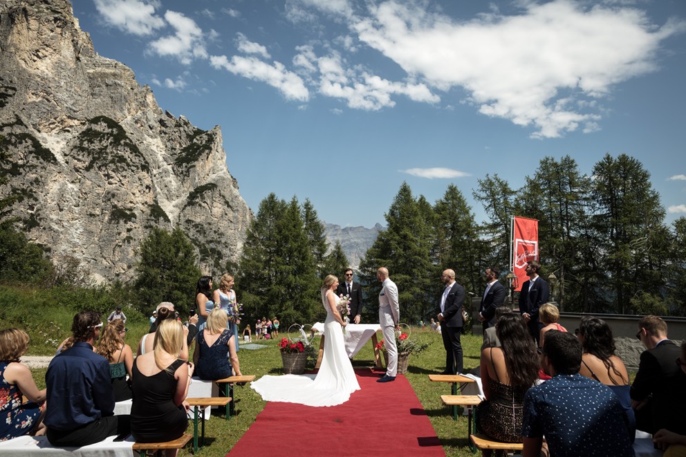 Freie Trauung vor spektakulärer Bergkulisse in Südtirol – Brautpaar, Gäste und roter Teppich vor den Felsen der Alpen, ideal für eine sommerliche Alpenhochzeit.