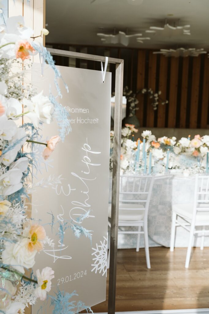 Willkommensschild und Tischdekoration mit Blumen - Hochzeitsfloristik für Berghochzeit